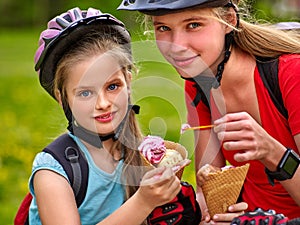 Girls with bicycle rucksack eating ice cream cone summer park.
