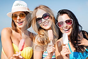 Girls in bikinis with ice cream on the beach