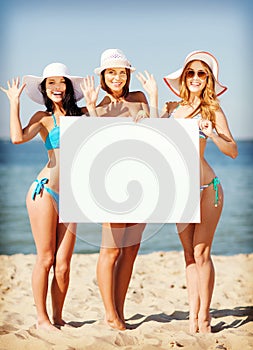 Girls with blank board on the beach