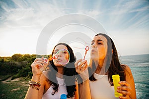 Girls blowing bubbles over the sea