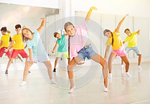 Girls and boys doing dance workout during group class in fitness center