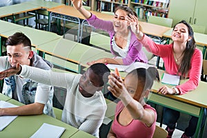 Girls and boys raising their hands in the class