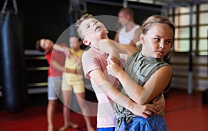 Girls and boys training chin strike in gym