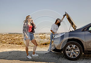 Girls with a broken a car on country road