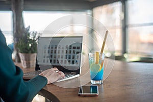 Girls in caffe typing on laptop and relaxing