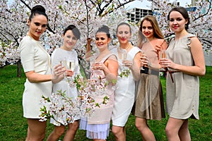 Girls with champagne celebrating in sakura's garden.