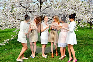 Girls with champagne celebrating in sakura's garden.