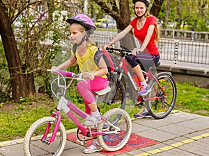 Girls children cycling on yellow bike lane.