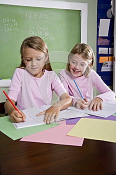 Girls in classroom doing schoolwork, writing