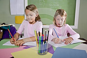 Girls in classroom doing schoolwork, writing