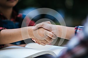 girls college student shake hand her friend