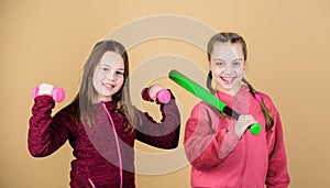 Girls cute kids with sport equipment dumbbells and baseball bat. We love sport. Child might excel in completely