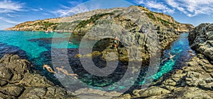 Girls dive on Baunty beach, cape Fiolent in Sevastopol, Crimea on a background of rocky shores. The concept of an travel, relax,