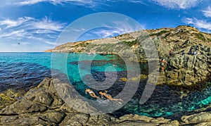 Girls dive on Baunty beach, cape Fiolent in Sevastopol, Crimea on a background of rocky shores. The concept of an travel, relax,