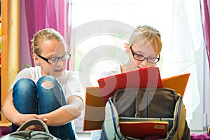 Girls doing homework and packing school bags