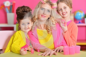 Girls doing manicure and hairstyle for mother