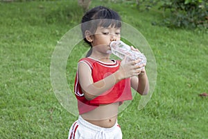 Girls drink water from plastic bottles. To quench thirst.