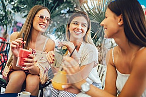 Girls drinking cocktail in cafe and having fun