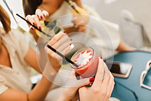 Girls drinking cocktail in cafe and having fun
