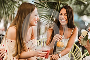 Girls drinking cocktail in cafe and having fun