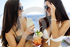 Girls drinking cocktails on beach