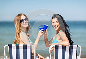 Girls with drinks on the beach chairs