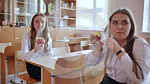 Girls eat apples in class during recess.