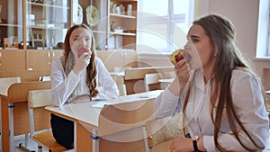 Girls eat apples in class during recess.