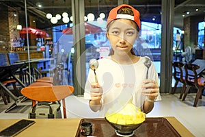 Girls are eating Bingsu Mango Cheese - Korean Dessert