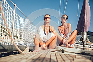 Girls enjoy the vacation on a yacht.