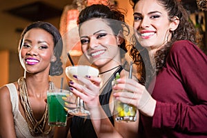 Girls enjoying nightlife in a club, drinking cocktails
