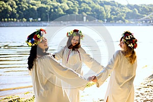 Girls in ethnic clothes with wreath of flowers celebrating