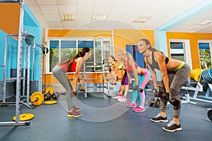 Girls in fitness club exercising with dumbbells