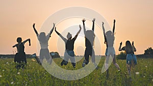 Girls friends are jumping against the background of an evening summer sunset.