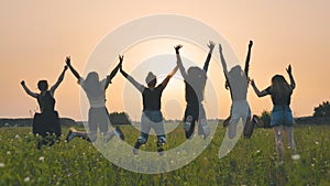 Girls friends are jumping against the background of an evening summer sunset.