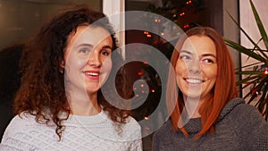 Girls with a glass of mulled wine communicate at a festive party