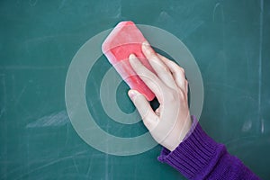 Girls hand in elementary school cleaning board with sponge