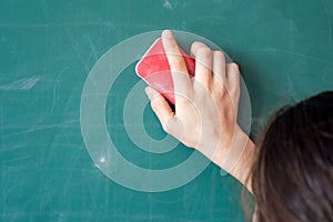 Girls hand in elementary school cleaning board with sponge