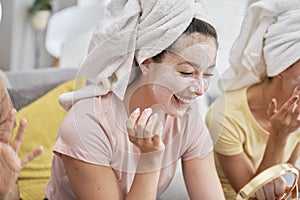 Girls having fun while applying a facial mask