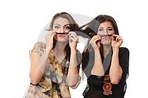 Girls having fun and making mustaches out of each others hair