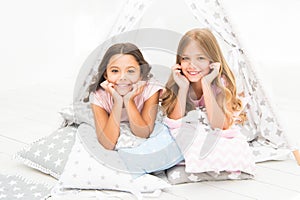 Girls having fun tipi house. Girlish leisure. Sisters share gossips having fun at home. Pajamas party for kids. Cozy