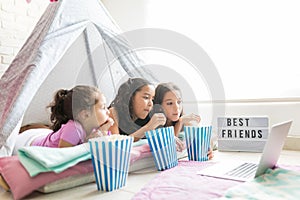 Girls Having Popcorns While Watching Movie On Laptop In Tipi