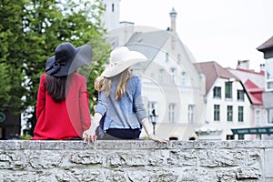 Girls hold hands sitting on the fence