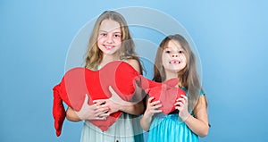 Girls hug red plush heart toy symbol love. Sisterhood concept. Valentines day. Friendly relations siblings. Family love