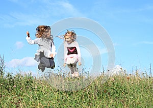 Girls jumping in grass