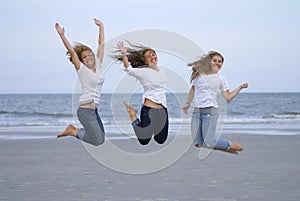 Girls Jumping For Joy on Beach