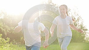 girls kid dream together run in the park at sunset. fun happy family people in the park concept. two sisters playing