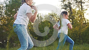 girls kid dream together run in the park at sunset. happy family people in the park concept. two sisters playing catch