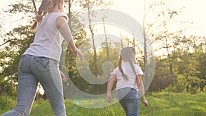 girls kid dream together run in the park at sunset. happy family people in the park concept. two sisters playing catch