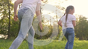 girls kid dream together run in the park at sunset. happy family people in the park concept. two sisters playing catch